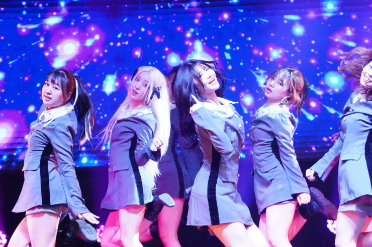 K-POPダンスショーケースイベント「Dance it UP」大阪開催のステージ写真。女性ダンサーたちが照明演出の中でパフォーマンスを披露している。